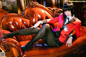 A woman sitting on a couch holding a credit card.