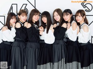 A group of young women posing in front of a blackboard.