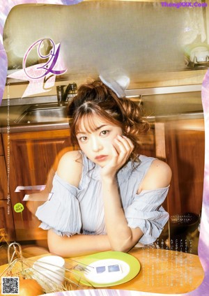 A magazine with a picture of a woman sitting at a table.