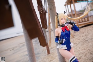 A woman in a blue and white outfit on a beach.