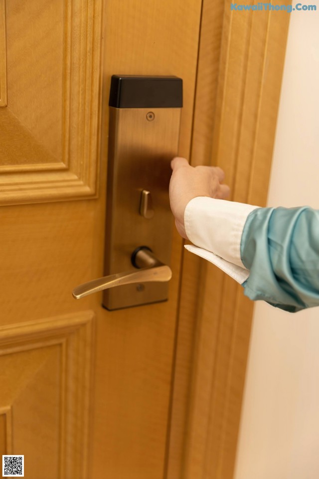 A person is opening a door with a paper towel.