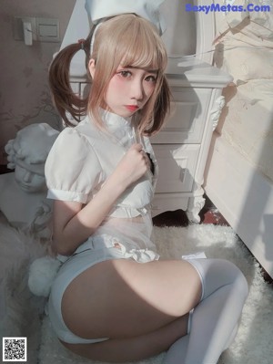 A woman in a white dress holding a white rabbit.