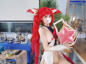 A woman with red hair is posing naked on a chair.