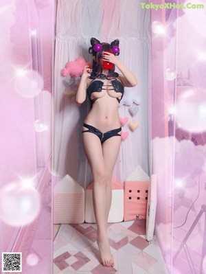 A woman in a black lingerie posing for the camera.