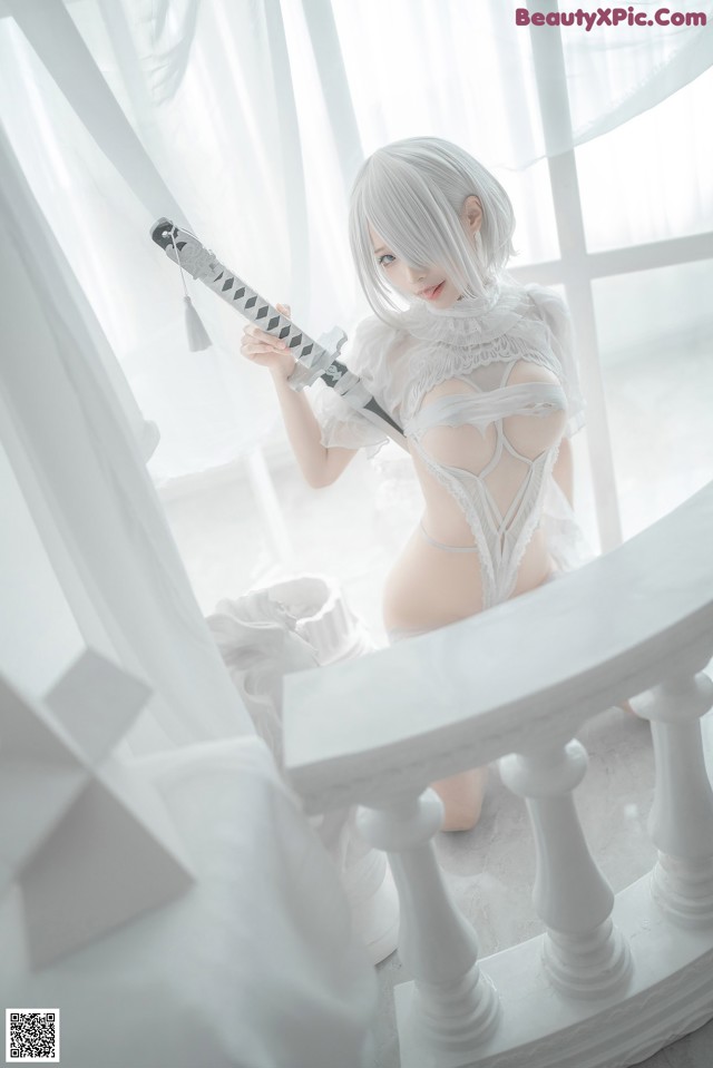 A woman in a white lingerie holding a sword.