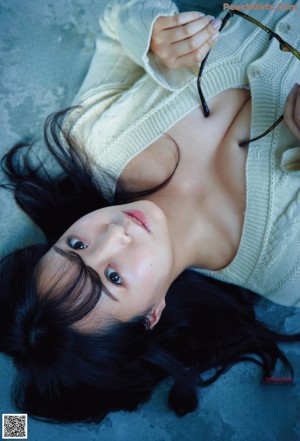 A woman in a white bra sitting on a window sill.