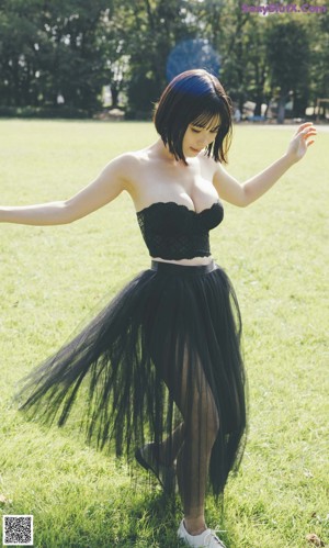 A woman in a black dress posing for a picture.