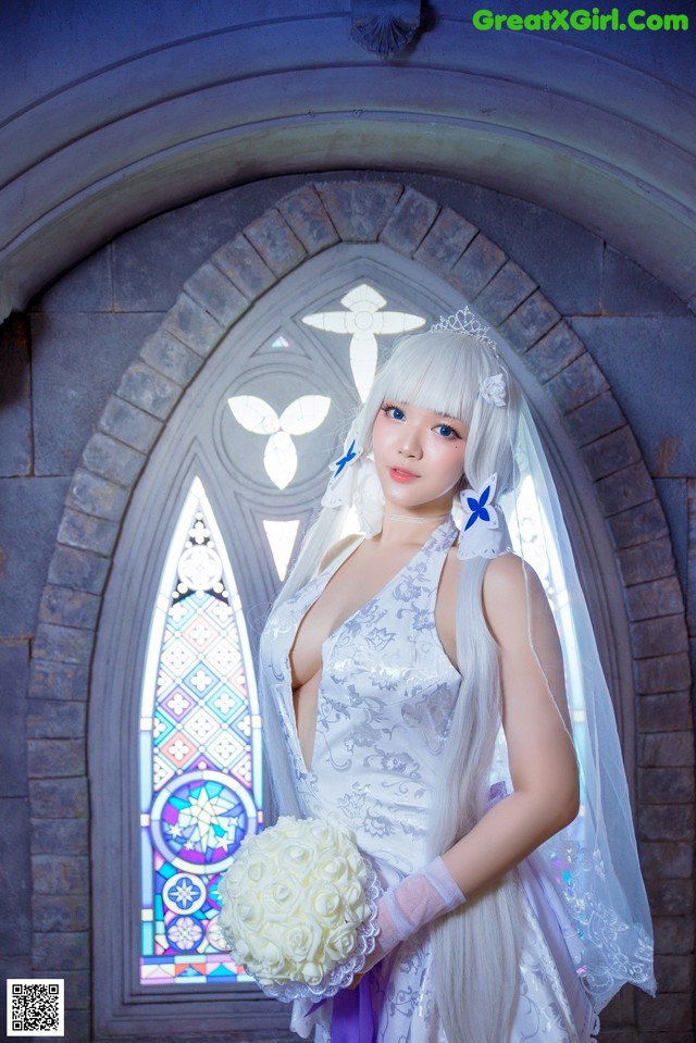 A woman in a wedding dress holding a bouquet of flowers.