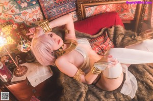 A woman with pink hair is posing in a room.