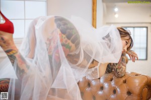 A woman in a wedding dress standing in front of a window.