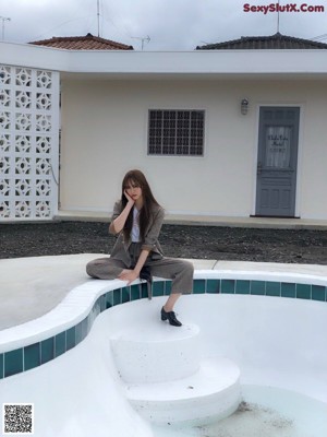 a japanese woman with long brown hair and a white shirt